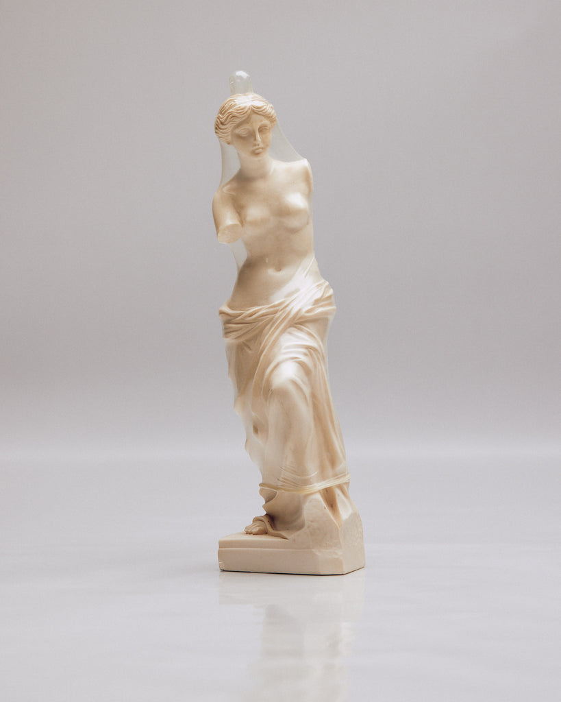 Classic statue of Venus depicted with a vegan Jonny condom placed on her head, representing a fusion of ancient artistry and contemporary health and lifestyle choices such as veganism and safe sexual practices.